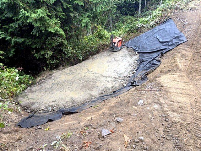 Compacted slope with geotextile and plate compactor