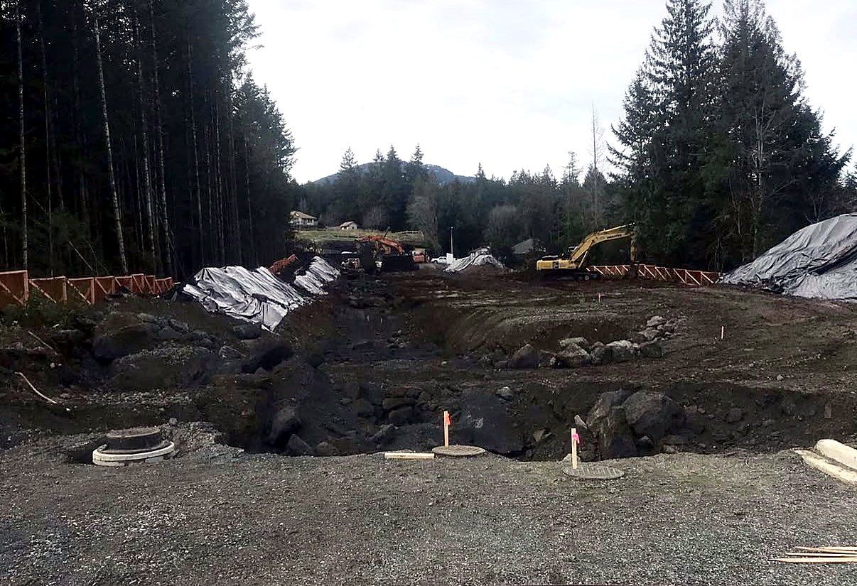 Subdivision site during excavation: rock, open trenches and manhole bases