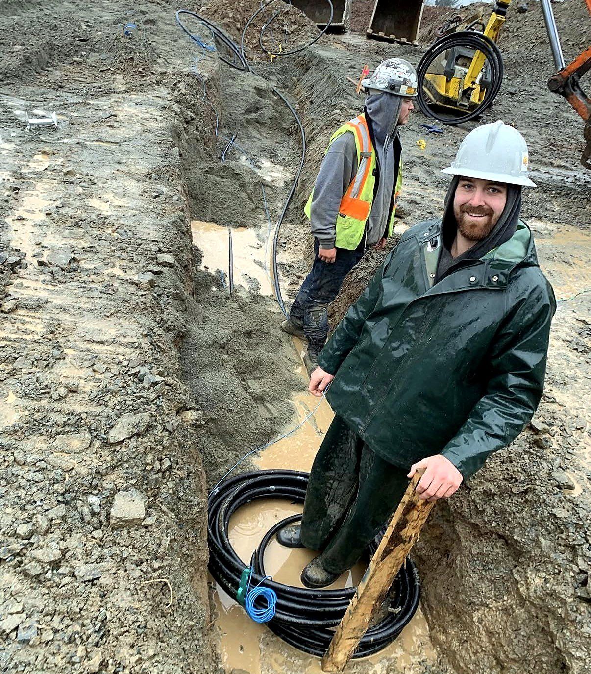 Crew installing water service lines in a trench